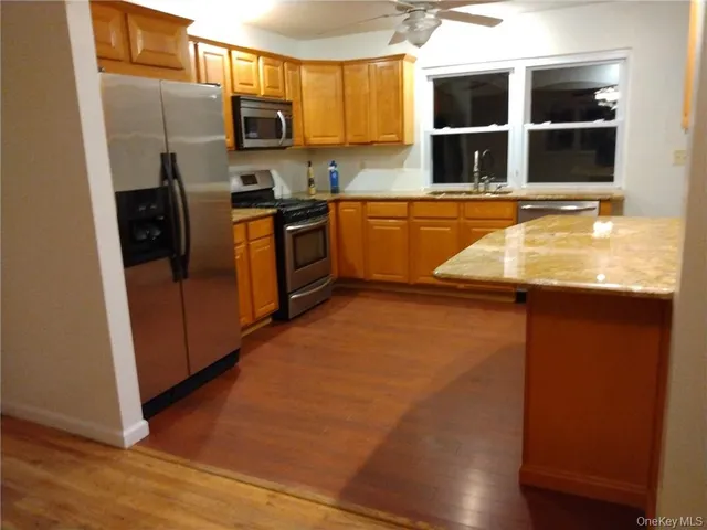 a kitchen with stainless steel appliances granite countertop a stove a sink and a refrigerator