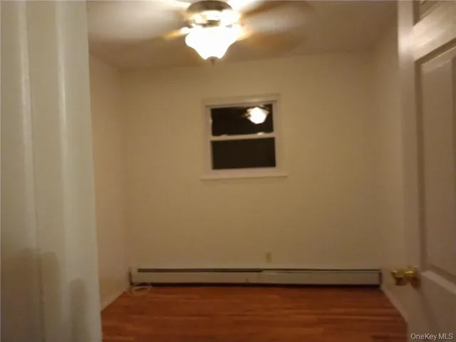 a view of a small space with wooden floor and a ceiling fan