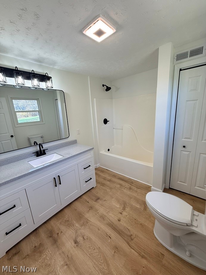 144 Aberdeen Road Steubenville, OH 43953 - Photo 24 of 34 Full bath featuring vanity, a textured ceiling, light wood-type flooring, and shower / washtub combination