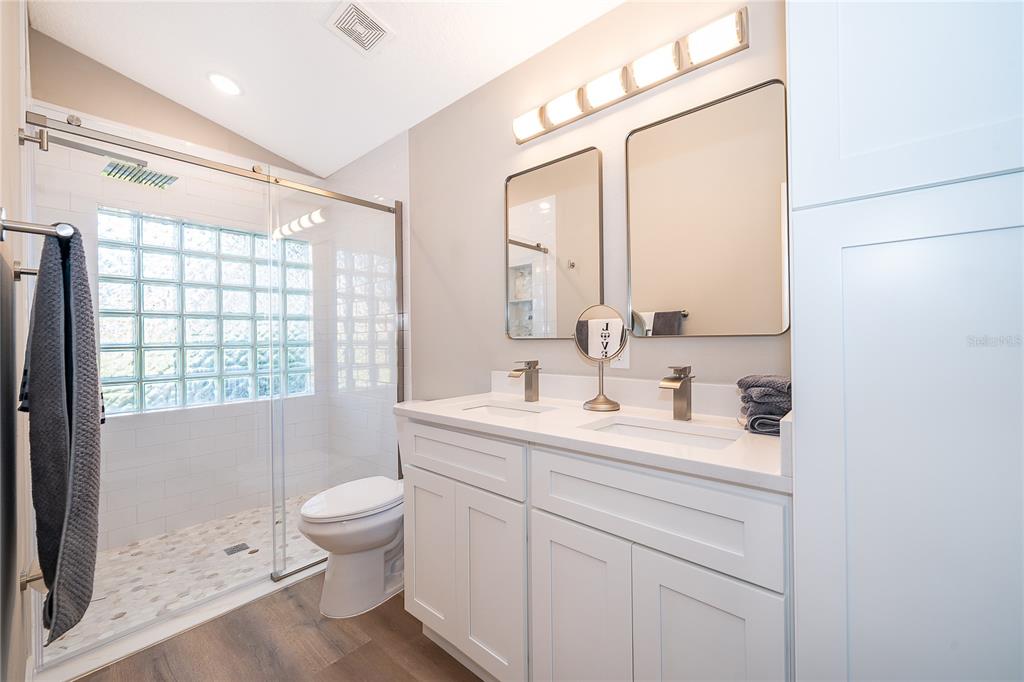 1652 Riveredge Road Oviedo, FL 32766 - Photo 13 of 22 a bathroom with a toilet a sink a mirror a window and vanity
