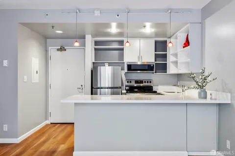 a kitchen with stainless steel appliances granite countertop a sink refrigerator and cabinets