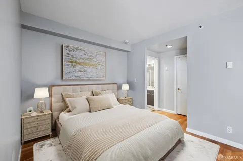 a bedroom with a bed and a painting on the wall