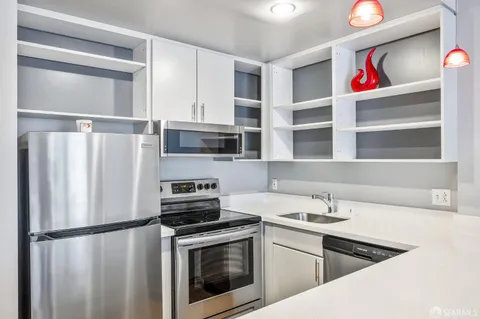 a kitchen with a refrigerator sink and cabinets