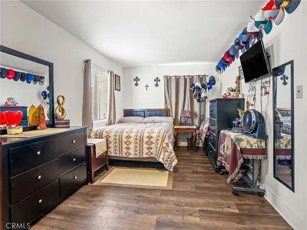 a bedroom with a bed a flat screen tv and dresser