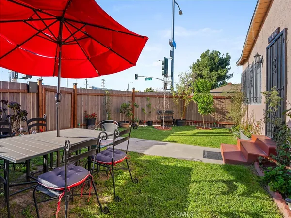 a view of a backyard with table and chairs under an umbrella