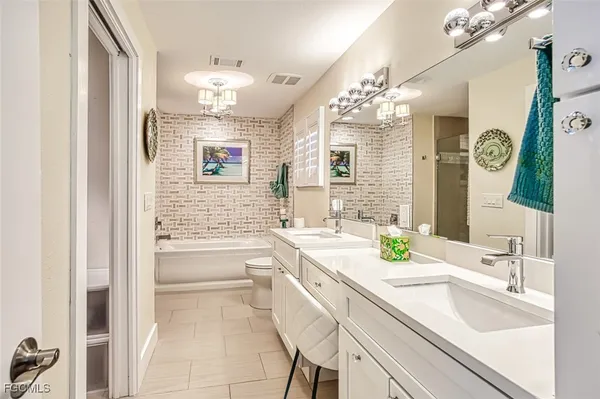 a bathroom with a sink a tub and a mirror