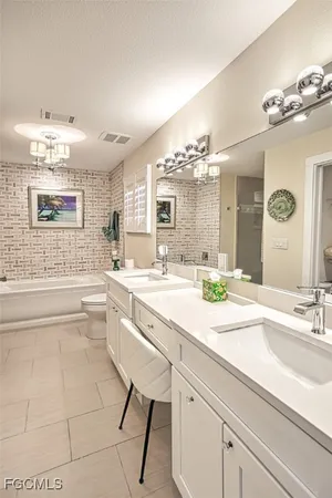 a bathroom with a granite countertop sink a large mirror and a bathtub