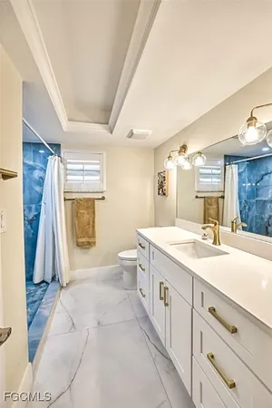 a spacious bathroom with a granite countertop sink a toilet a mirror and a tub