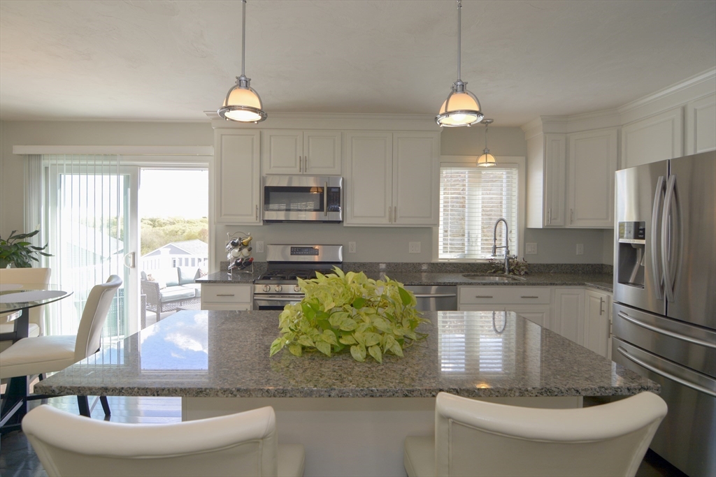 12 Gedney Drive Peabody, MA 01960 - Photo 10 of 41 a kitchen with sink a refrigerator and chairs