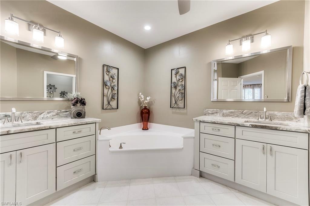 8471 Southbridge Drive, Unit 1 Estero, FL 33967 - Photo 23 of 37 a bathroom with a granite countertop sink mirror and bathtub