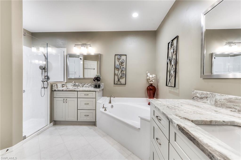 8471 Southbridge Drive, Unit 1 Estero, FL 33967 - Photo 24 of 37 a bathroom with a granite countertop sink a toilet a large mirror and vanity