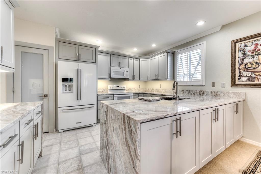8471 Southbridge Drive, Unit 1 Estero, FL 33967 - Photo 3 of 37 a kitchen with stainless steel appliances granite countertop a sink stove and refrigerator
