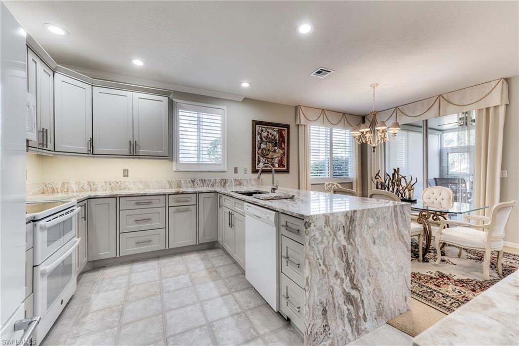 8471 Southbridge Drive, Unit 1 Estero, FL 33967 - Photo 4 of 37 a large kitchen with stainless steel appliances lots of counter space and wooden floor