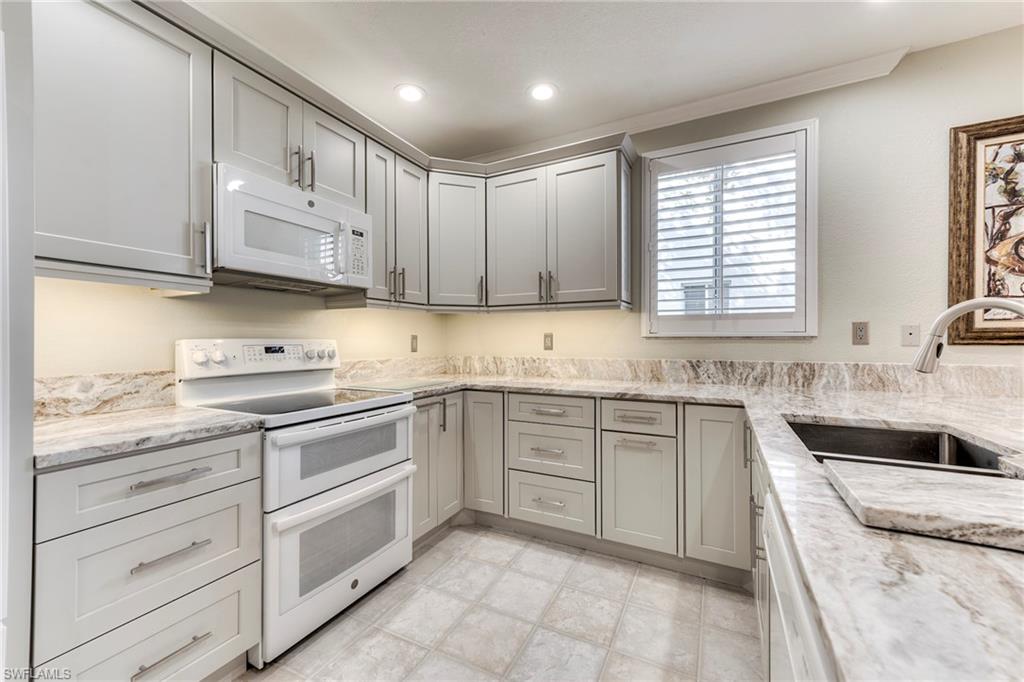 8471 Southbridge Drive, Unit 1 Estero, FL 33967 - Photo 5 of 37 a kitchen with granite countertop white cabinets white stainless steel appliances with a sink and dishwasher