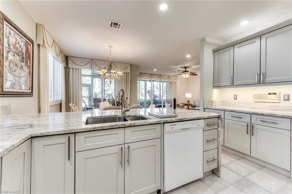 8471 Southbridge Drive, Unit 1 Estero, FL 33967 - Photo 6 of 37 a kitchen with kitchen island white cabinets and white appliances