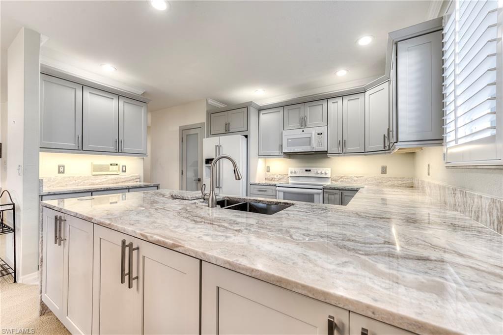 8471 Southbridge Drive, Unit 1 Estero, FL 33967 - Photo 7 of 37 a kitchen with stainless steel appliances granite countertop a sink stove and cabinets