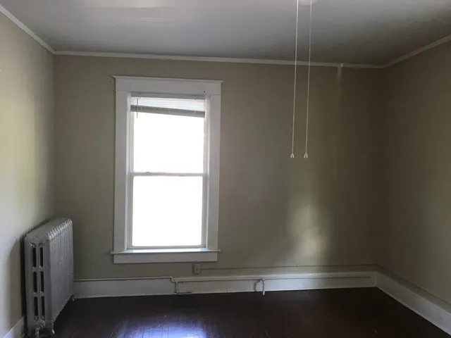 an empty room with a fireplace and windows