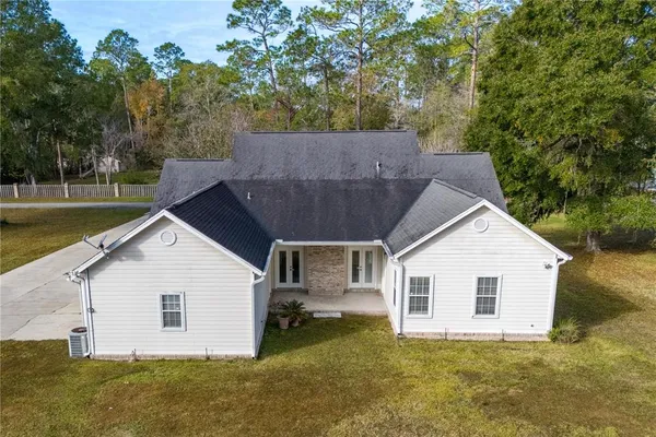 an aerial view of residential house with outdoor space and trees all around