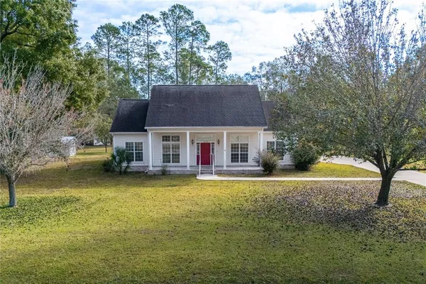 a view of a house with backyard and balcony