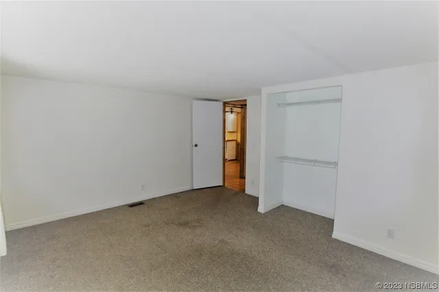 a view of an empty room and closet area