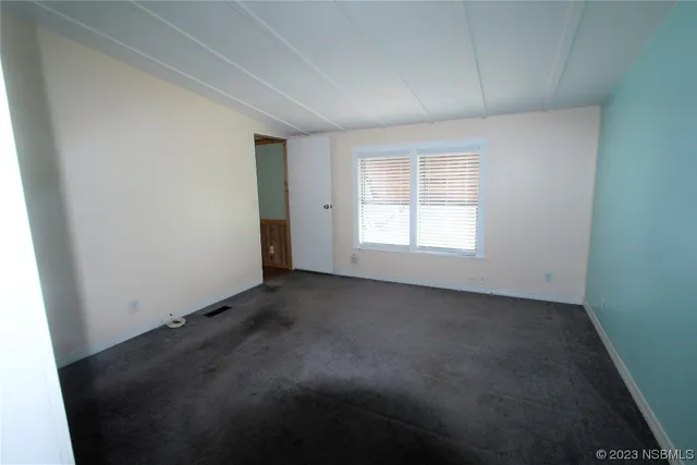 an empty room with a windows and closet