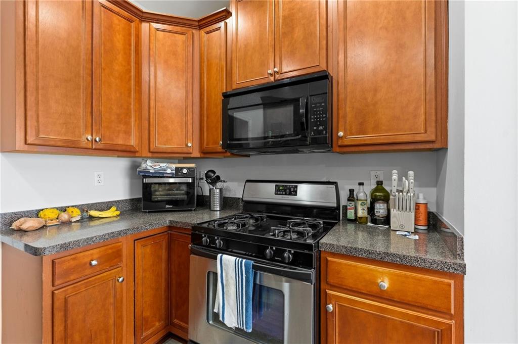 293 Jordan Street Southeast Atlanta, GA 30315 - Photo 9 of 26 a kitchen with granite countertop a stove top oven cabinetry a sink and dishwasher