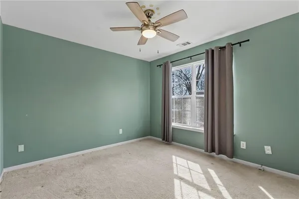 a view of a livingroom with a ceiling fan and window