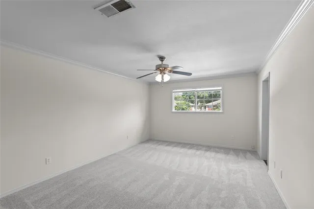 an empty room with windows and fan