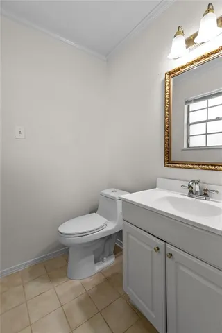 a bathroom with a toilet sink vanity and mirror