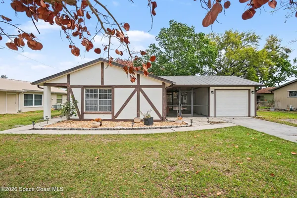 a view of a house with backyard and sitting area
