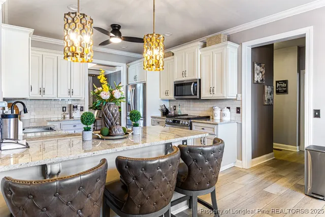 a kitchen with stainless steel appliances granite countertop a sink a stove and a wooden floors