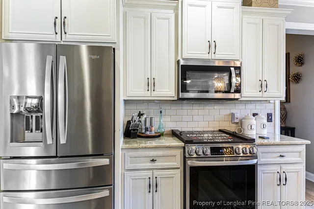 a kitchen with stainless steel appliances granite countertop a stove a refrigerator and cabinets