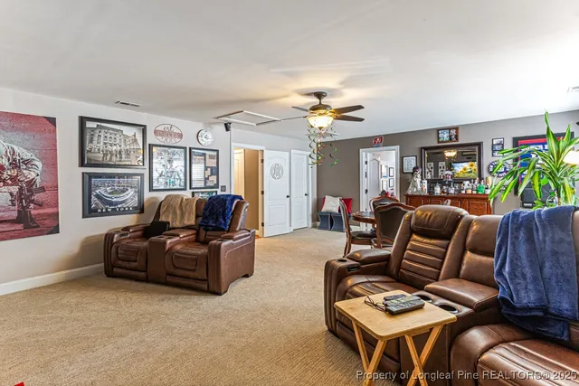 a living room with furniture ceiling fan and a window