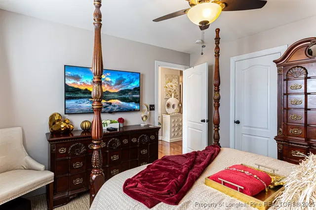 a bedroom with a bed dresser and a chandelier