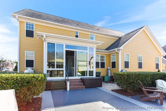 a view of a house with a chairs and table in a patio