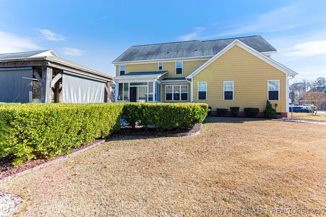 a view of a house with a yard and potted plants