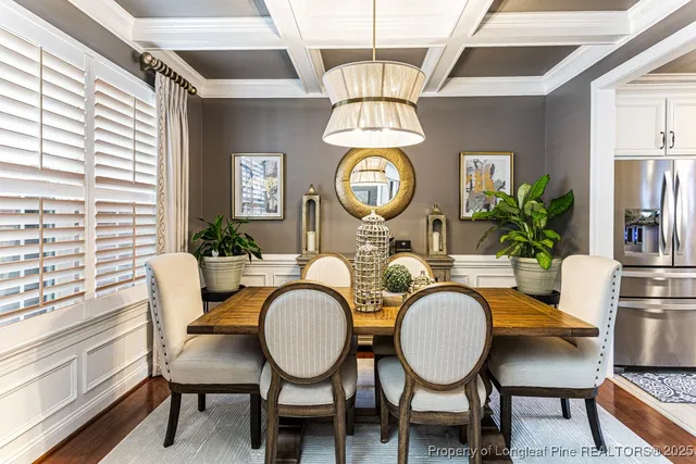 a dining room with furniture a rug a fireplace and a large window