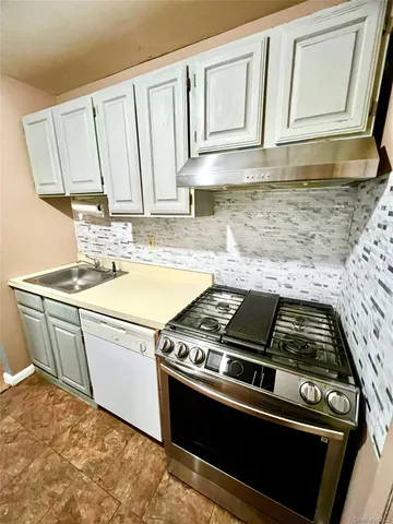 a kitchen with a stove and white cabinets