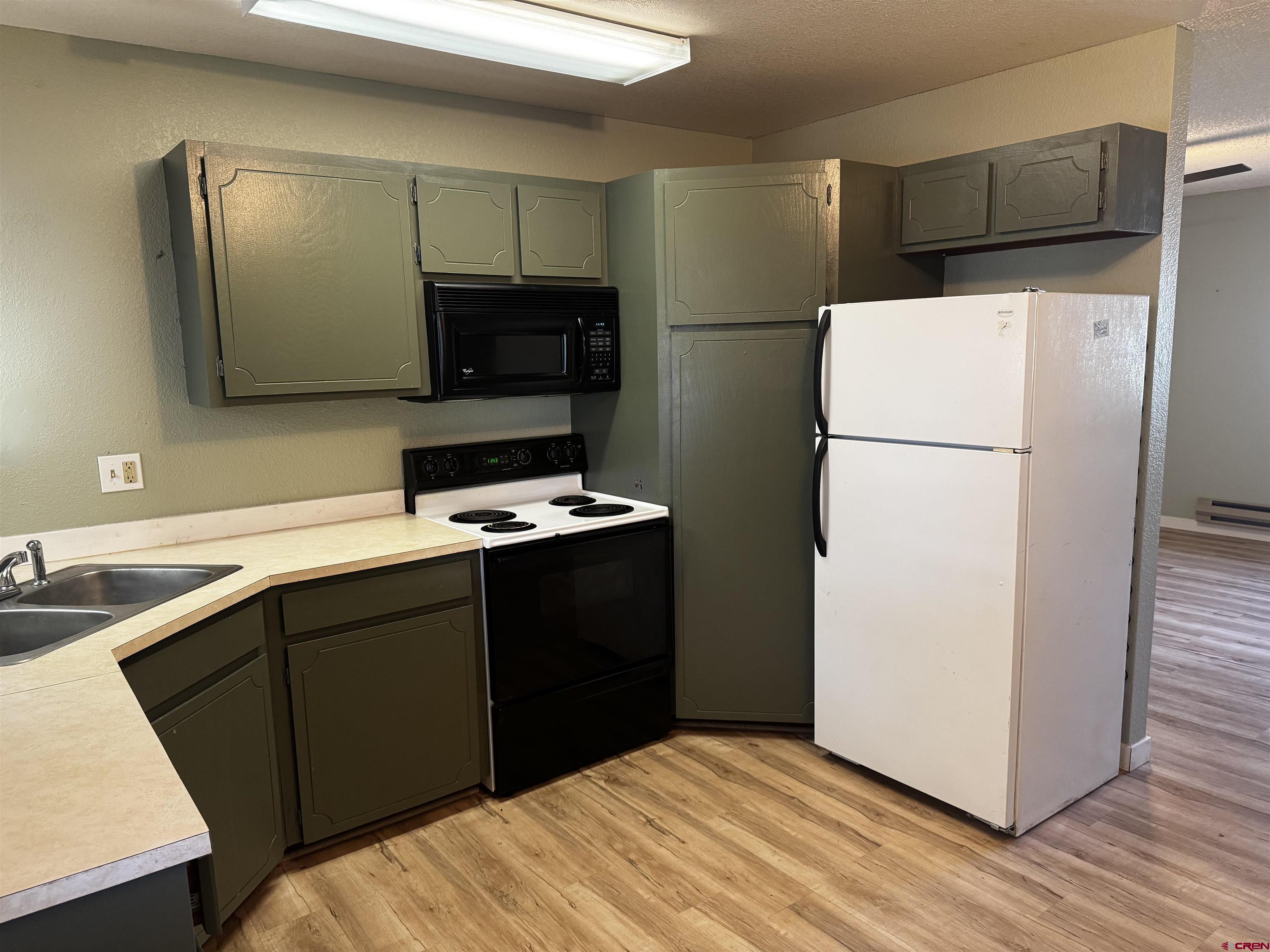 345 1/2 Northwest 4th Street Cedaredge, CO 81413 - Photo 13 of 28 a kitchen with a refrigerator and a stove