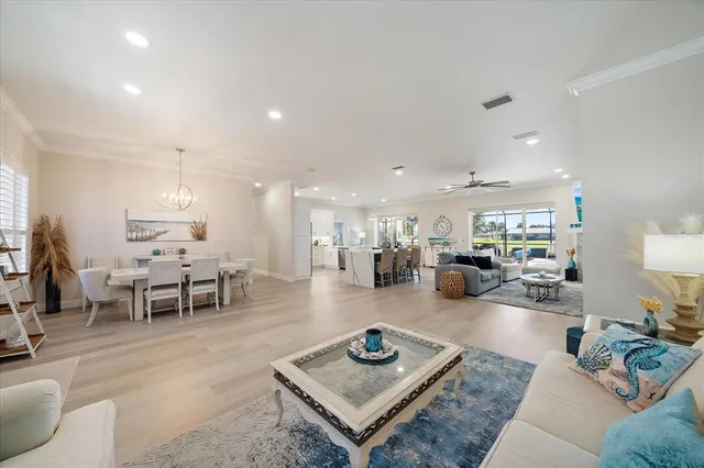 a living room with furniture and a dining table with wooden floor