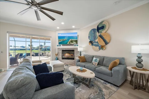 a living room with furniture a fireplace and a large window