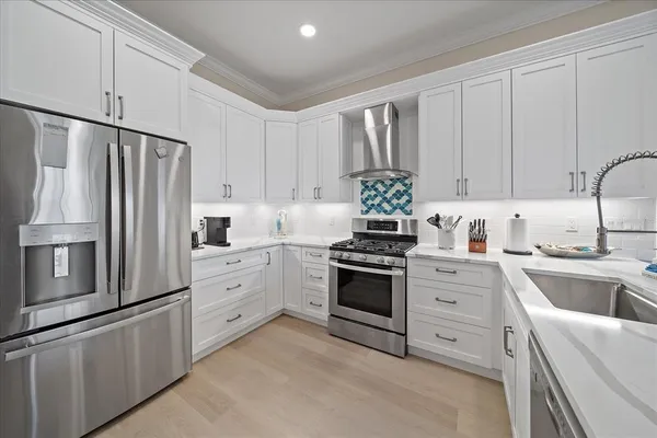 a kitchen with granite countertop white cabinets and stainless steel appliances