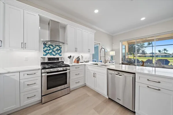 a kitchen with white cabinets and white appliances