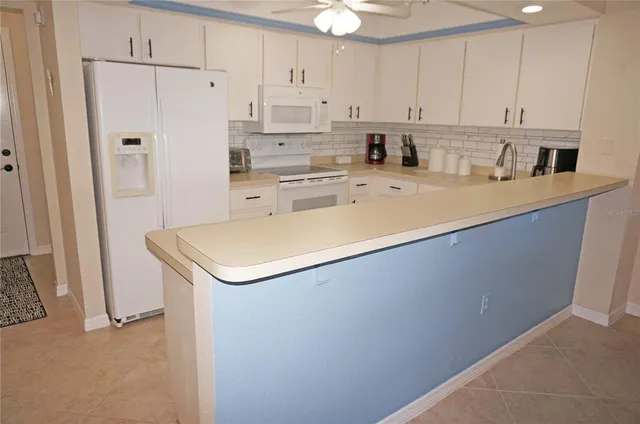 a kitchen with a sink a stove and white cabinets