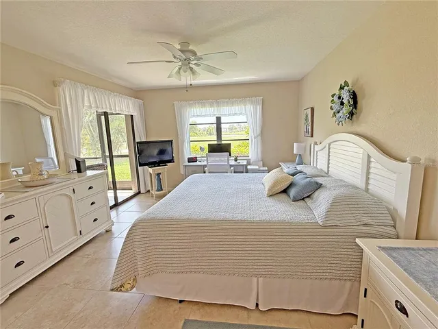 a bedroom with a large bed and wooden floor