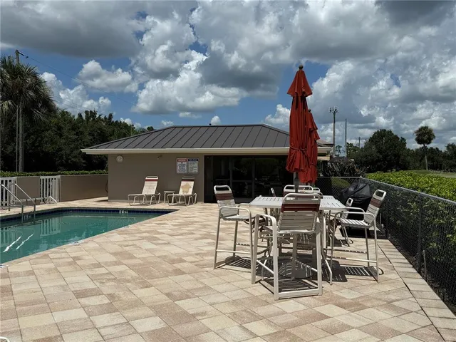 a view of a patio with a dining table and chairs with wooden fence