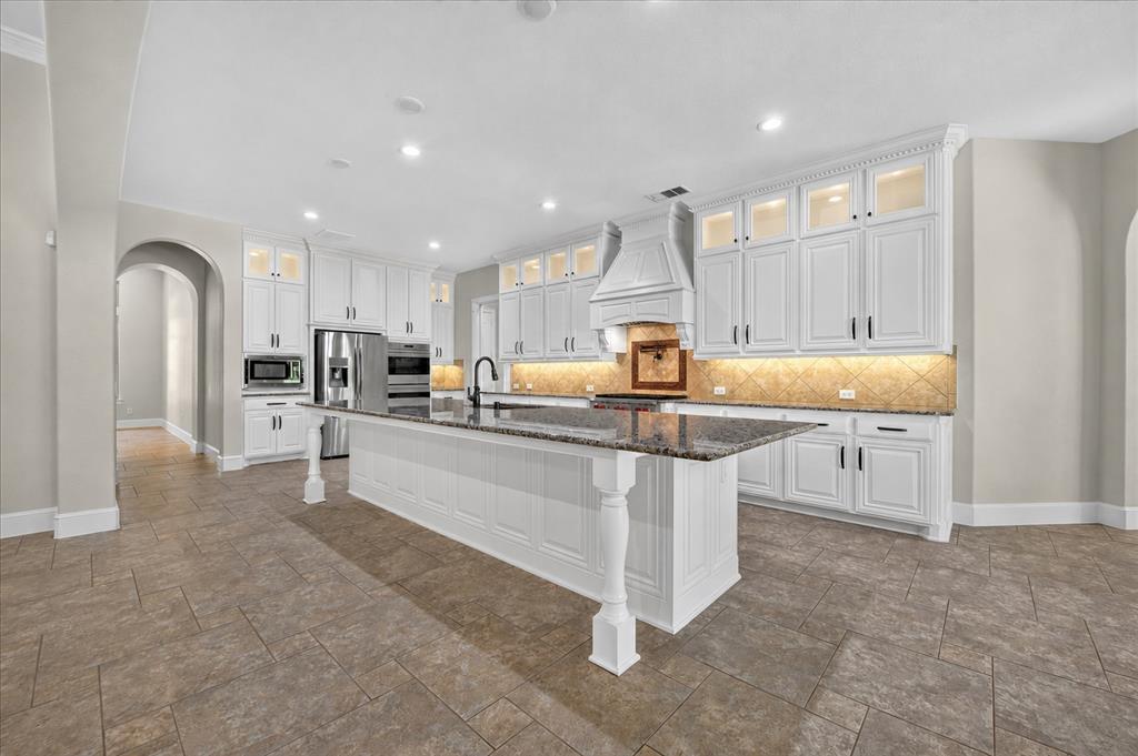 861 Hayden Road Lantana, TX 76226 - Photo 12 of 40 The kitchen has a massive center island, Wolf 6-burner cooktop, double ovens, pot filler, and under cabinet lighting.