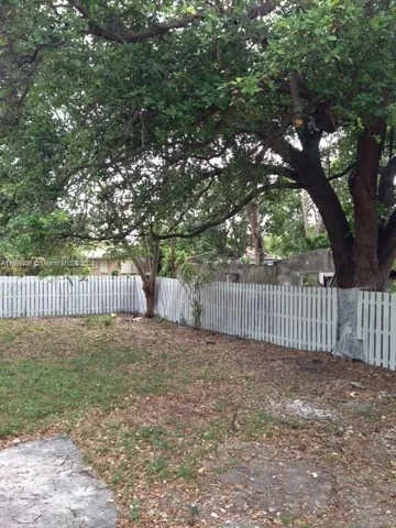 a view of a deck with a tree and wooden fence