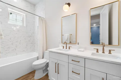 a bathroom with a toilet a sink a bathtub and a mirror