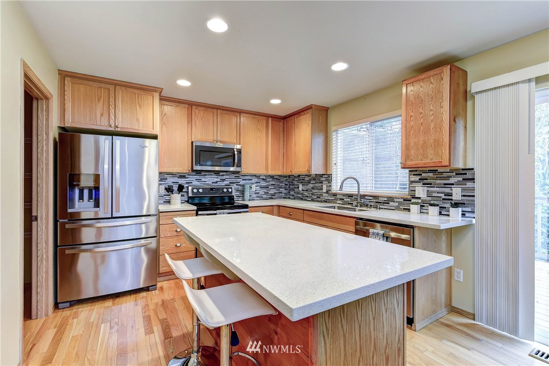 2324 194th Street Southeast Bothell, WA 98012 - Photo 9 of 22 a kitchen with stainless steel appliances a stove a sink a refrigerator and cabinets